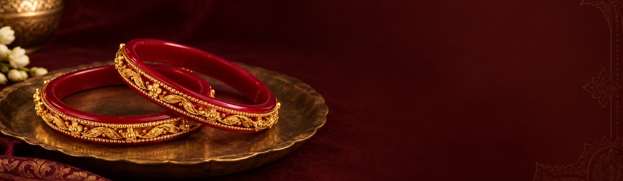 Red and gold bangles resting on an antique brass plate